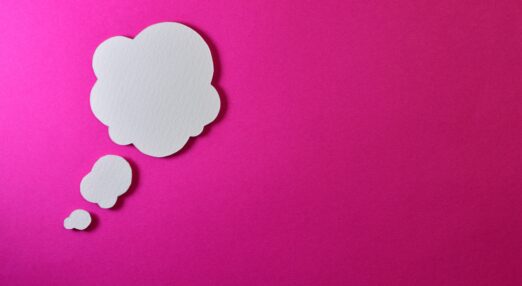 A white thought cloud on a pink background